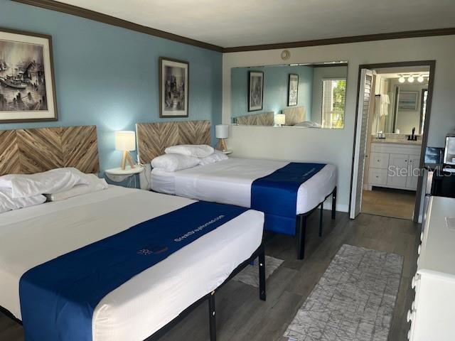 A hotel room features two beds with blue runners, wood headboards, and an attached bathroom — 7150 N TAMIAMI TRAIL UNIT C233, SARASOTA, FL