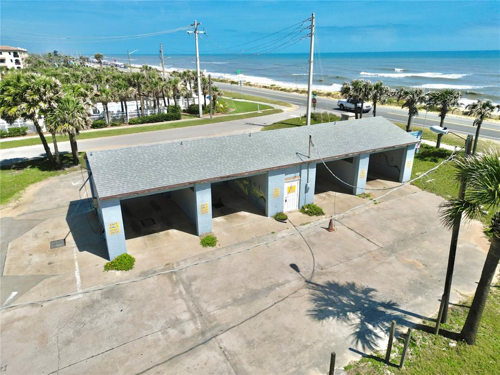 An aerial view of a small, light blue, multi-bay car wash building near the ocean — 2299 N OCEANSHORE BOULEVARD, FLAGLER BEACH, FL