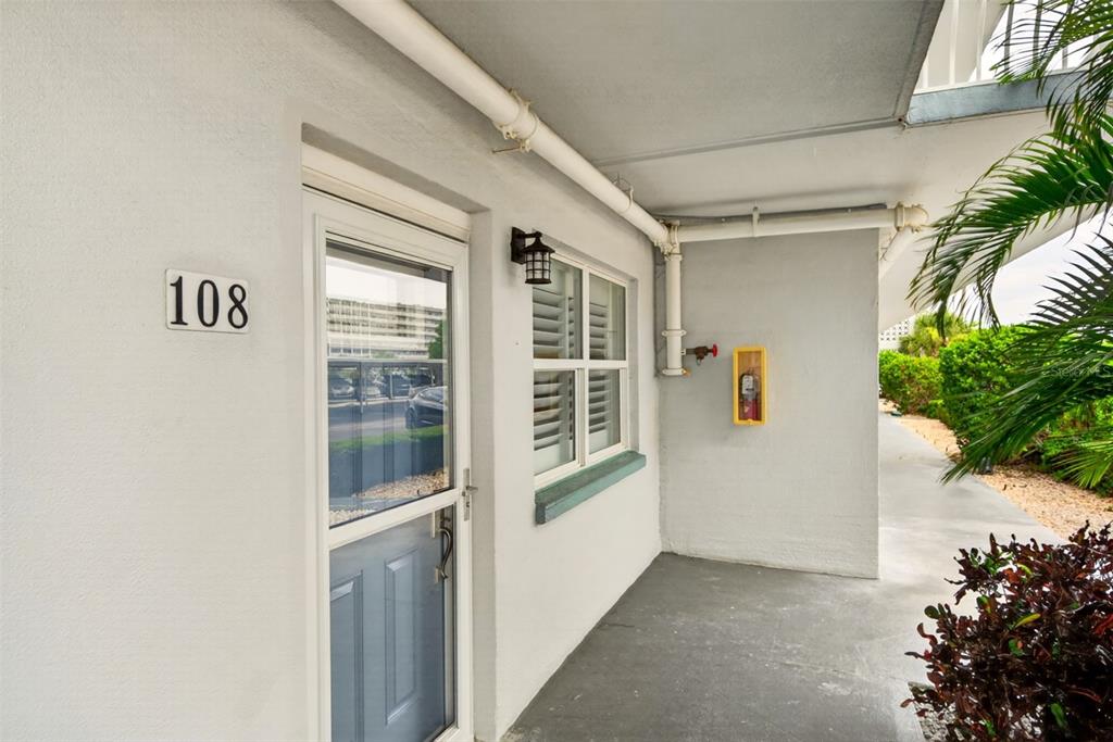 An exterior view of a building entrance with a blue door numbered 108 — 5925 SHORE BOULEVARD S UNIT 108, GULFPORT, FL
