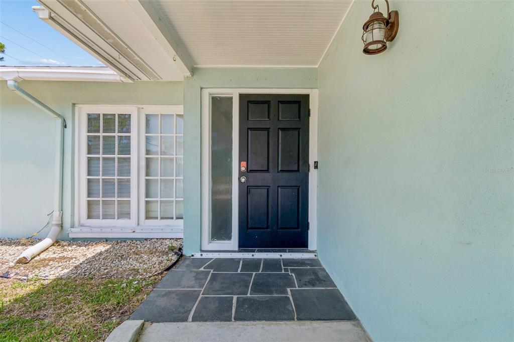 An open-concept living and dining area features light wood flooring, neutral walls, and modern furniture — 13691 SERENA DRIVE, LARGO, FL