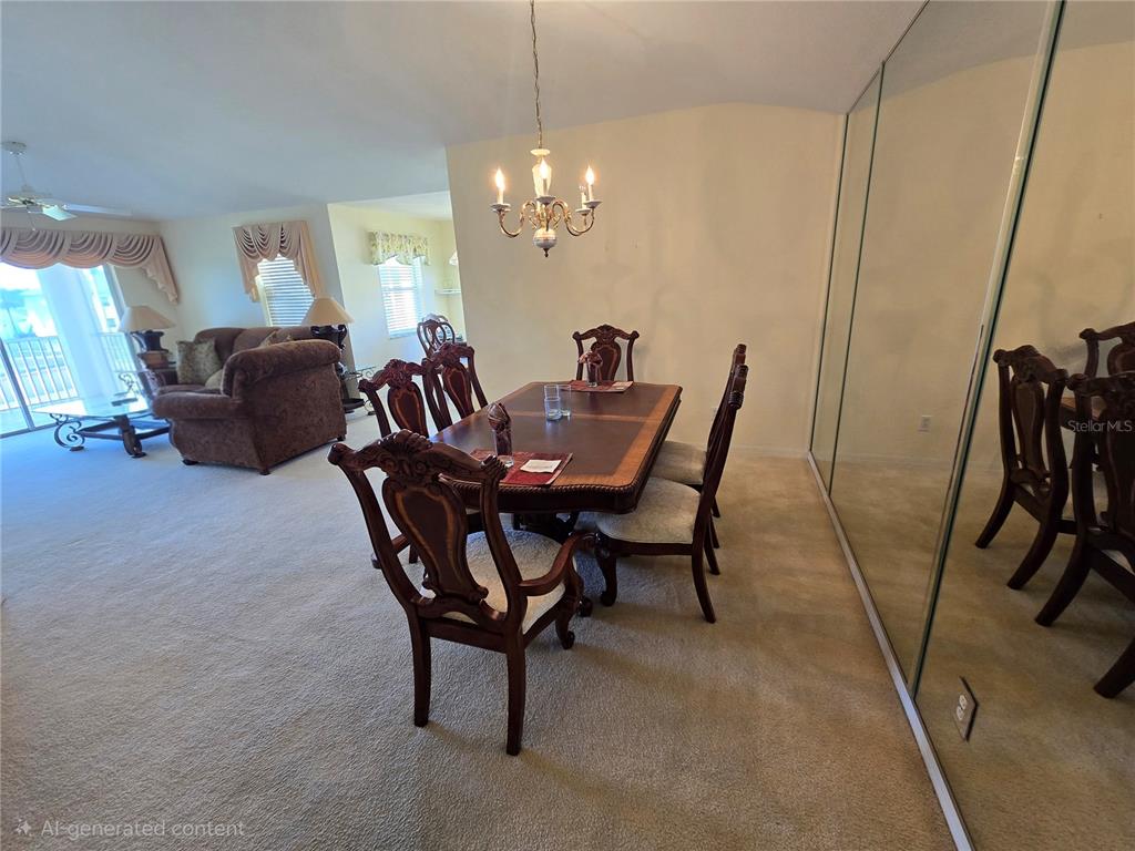 A dining area with a wooden table, chairs, and a chandelier sits near a mirrored wall — 5800 SABAL TRACE DRIVE UNIT 1002, NORTH PORT, FL