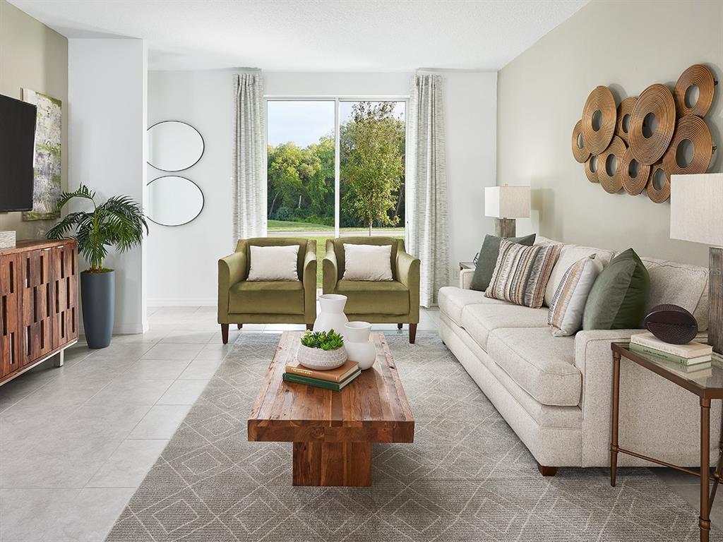 A living room features a beige sofa, two olive green armchairs, and a wooden coffee table — 9118 DALERA COVE, PALMETTO, FL