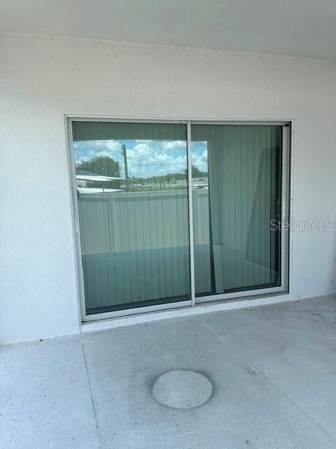 A sliding glass door opens onto a concrete patio area — 1062 SAND TORCH CIRCLE, DAVENPORT, FL