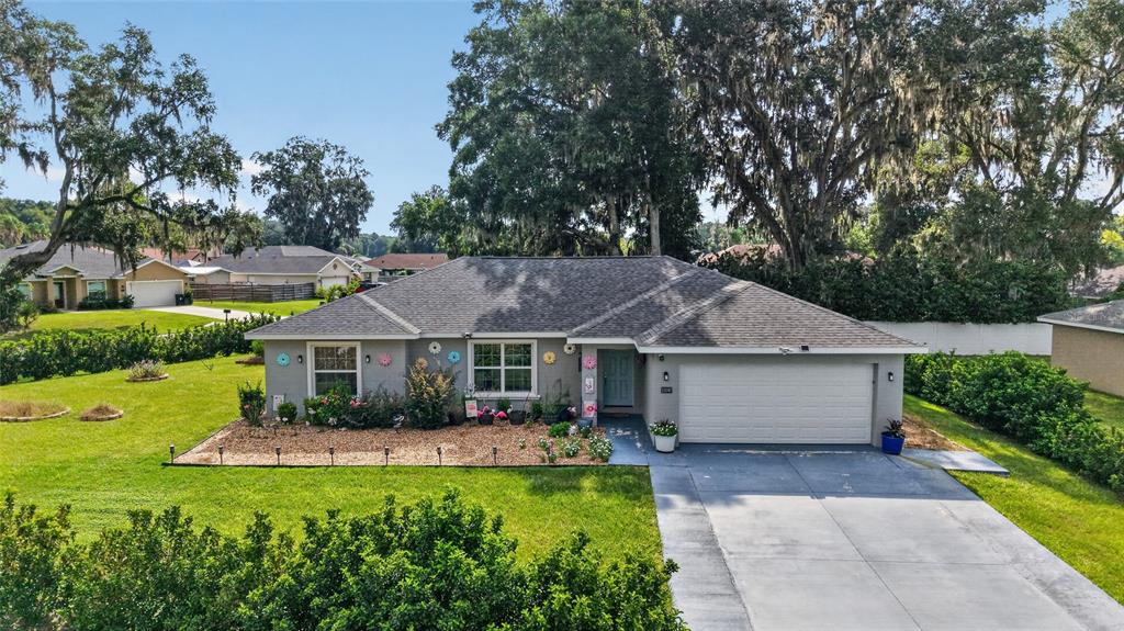 A single-story house with a gray exterior, a two-car garage, and a landscaped front yard — 10097 SW 78TH COURT, OCALA, FL