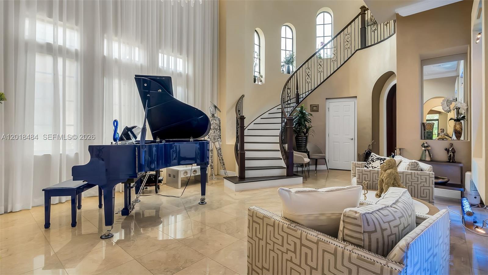 A grand foyer features a blue grand piano, a curved staircase, and tile flooring — 9587 Exbury Ct, Parkland FL 33076, PARKLAND, FL