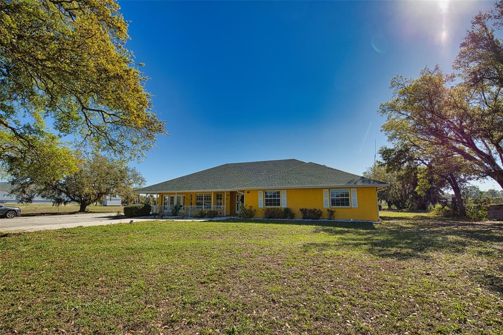 A yellow single-story house with a dark shingled roof sits on a grassy lot — 2820 PAN AMERICAN BOULEVARD, NORTH PORT, FL