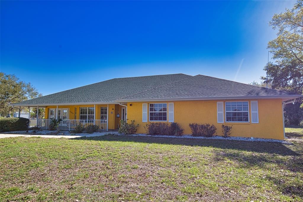 A yellow single-story house with a dark shingled roof and a front porch — 2820 PAN AMERICAN BOULEVARD, NORTH PORT, FL