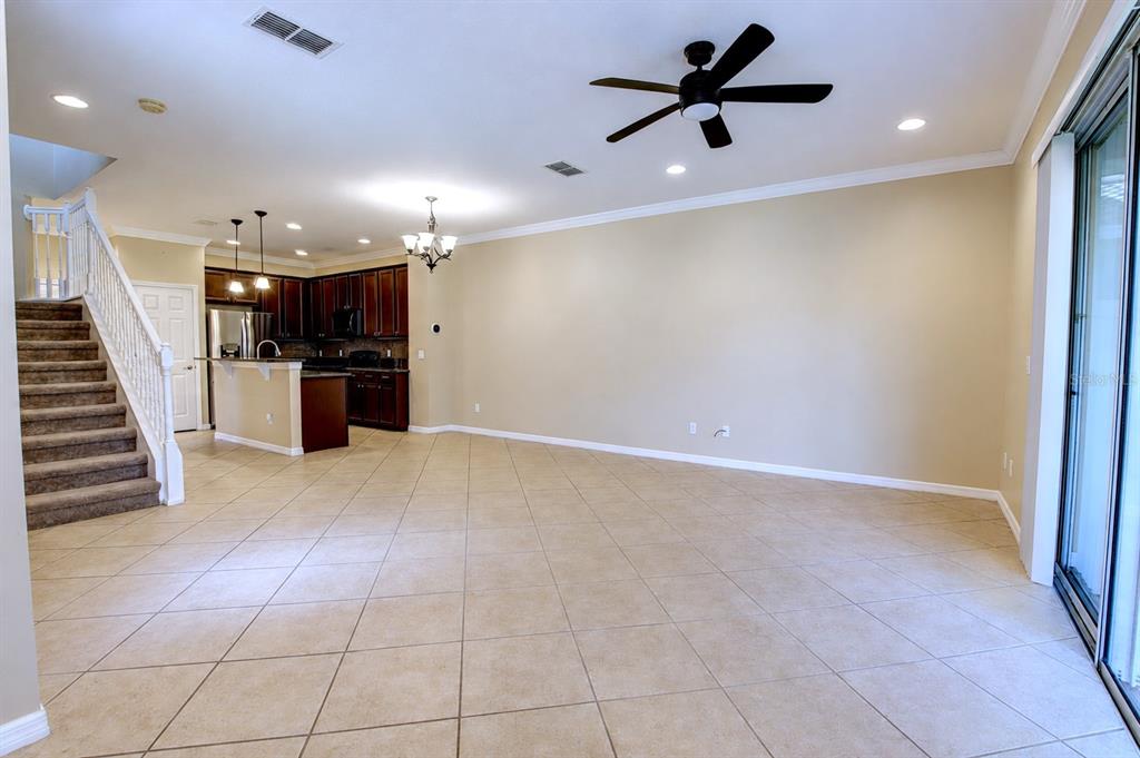 An open-concept living area features tile flooring, a staircase, and a kitchen with dark cabinets — 266 TERRACINA DRIVE, SANFORD, FL