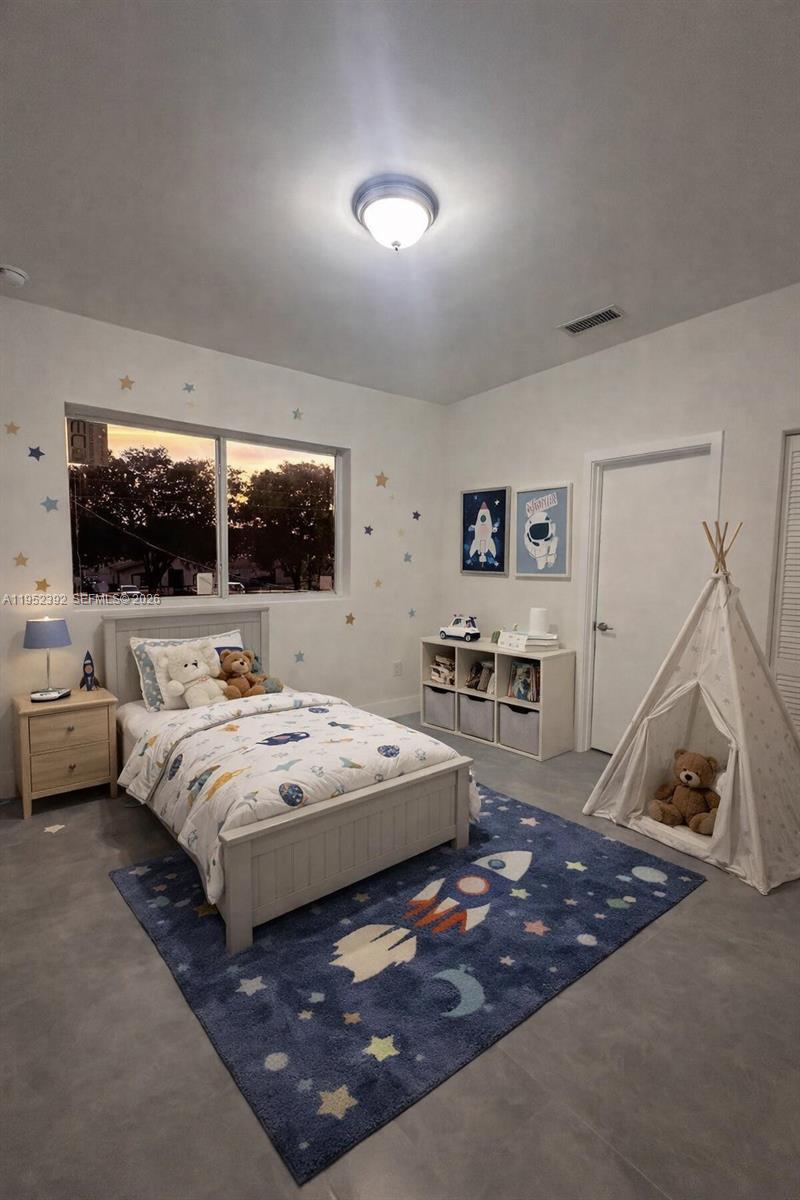 A child's bedroom features a rocket-themed rug, a teepee, and star decals on the walls — FORT LAUDERDALE, FL