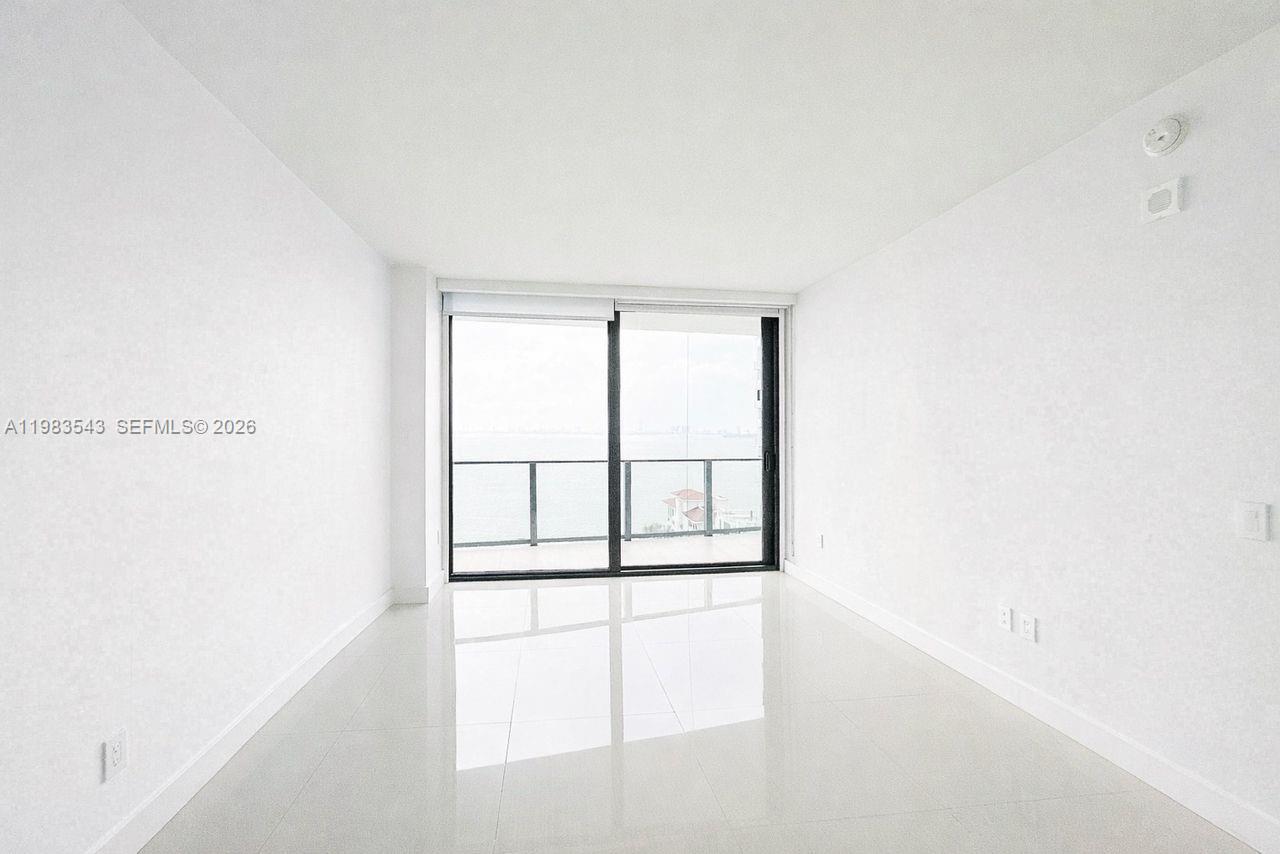 A modern kitchen features wood-grain cabinetry, white countertops, a central island, and stainless steel appliances — 460 NE 28th St # 1407, Miami FL 33137, MIAMI, FL