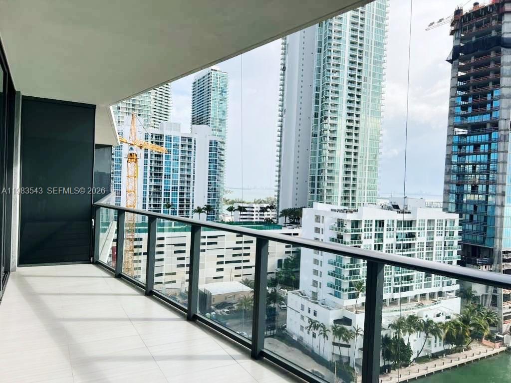 A modern kitchen with a central island and gray cabinetry opens into a living area — 460 NE 28th St # 1407, Miami FL 33137, MIAMI, FL