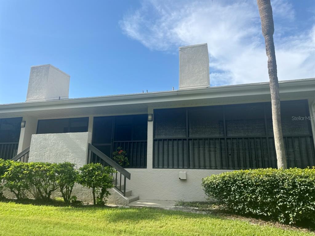 The exterior of a residential building features a screened-in porch, two chimneys, and landscaping — 1312 PASADENA AVENUE S UNIT 15, ST PETERSBURG, FL