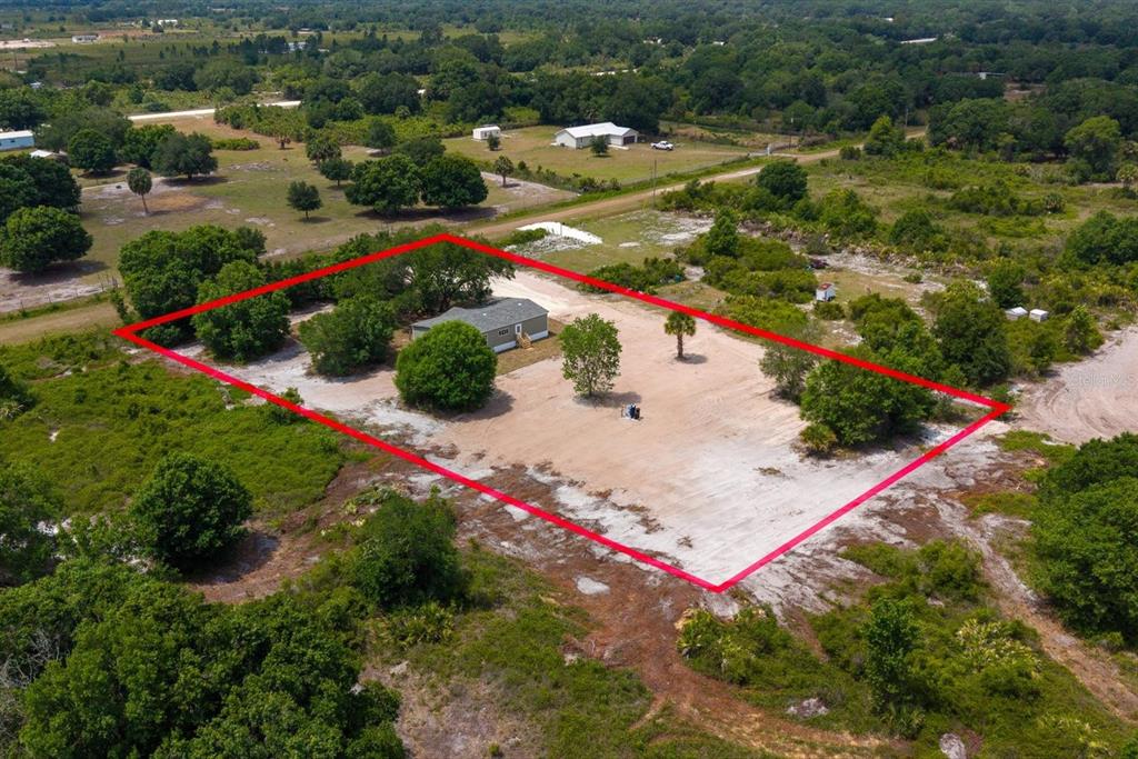 An aerial view shows a house situated on a large, sandy, partially wooded lot — 20213 NW 258TH STREET, OKEECHOBEE, FL