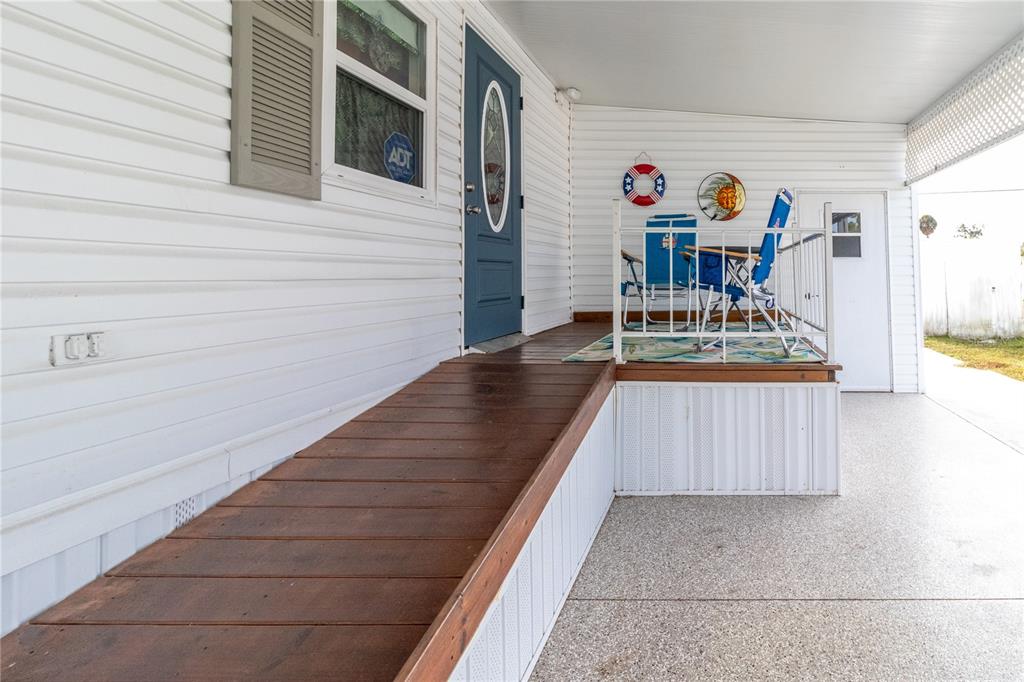 A wooden ramp leads to the front door of a home with a covered porch — 214 LEISURE WAY, PALMETTO, FL