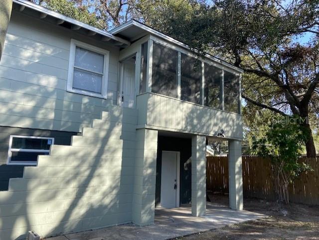 An exterior view of a two-story house featuring a screened-in porch and concrete block walls — 962 19 AVENUE S UNIT C, ST PETERSBURG, FL