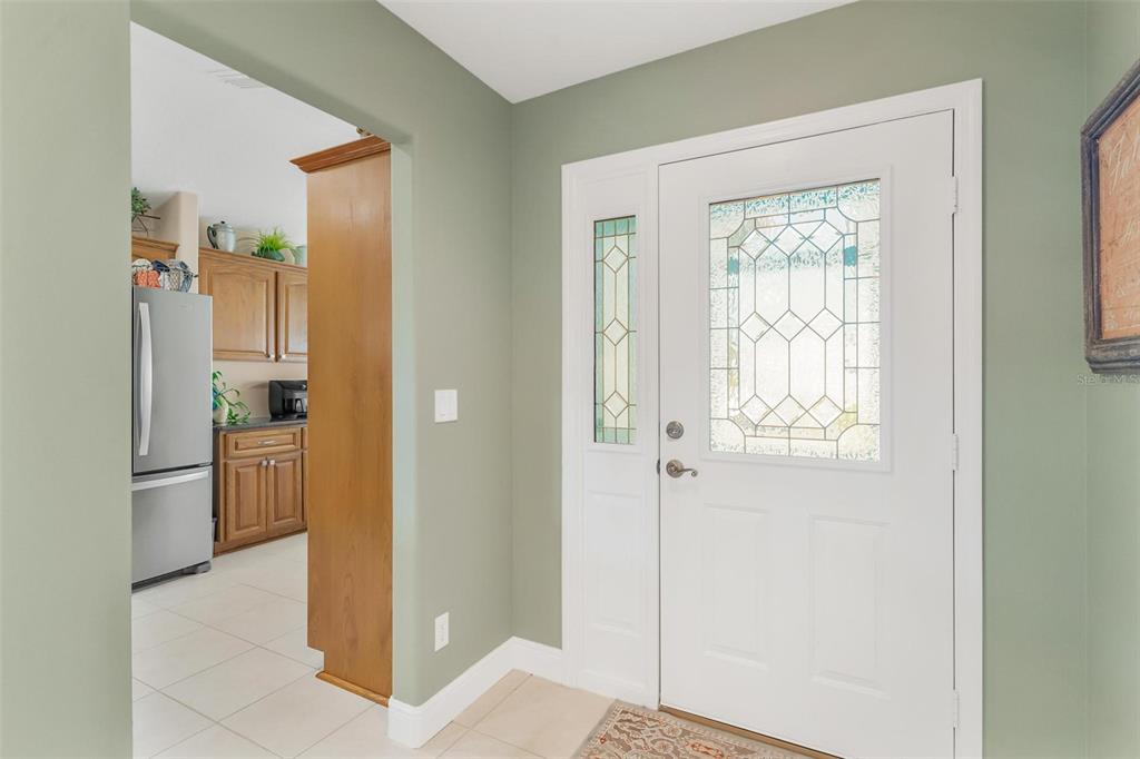 An entryway with a white front door and a view into a kitchen — 5486 BOUNTY CIRCLE, TAVARES, FL