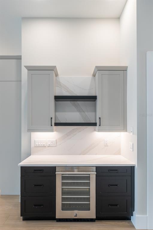A kitchen wet bar features dark lower cabinets, light upper cabinets, and a built-in wine cooler — 268 BLUE PEARL CT,, SARASOTA, FL