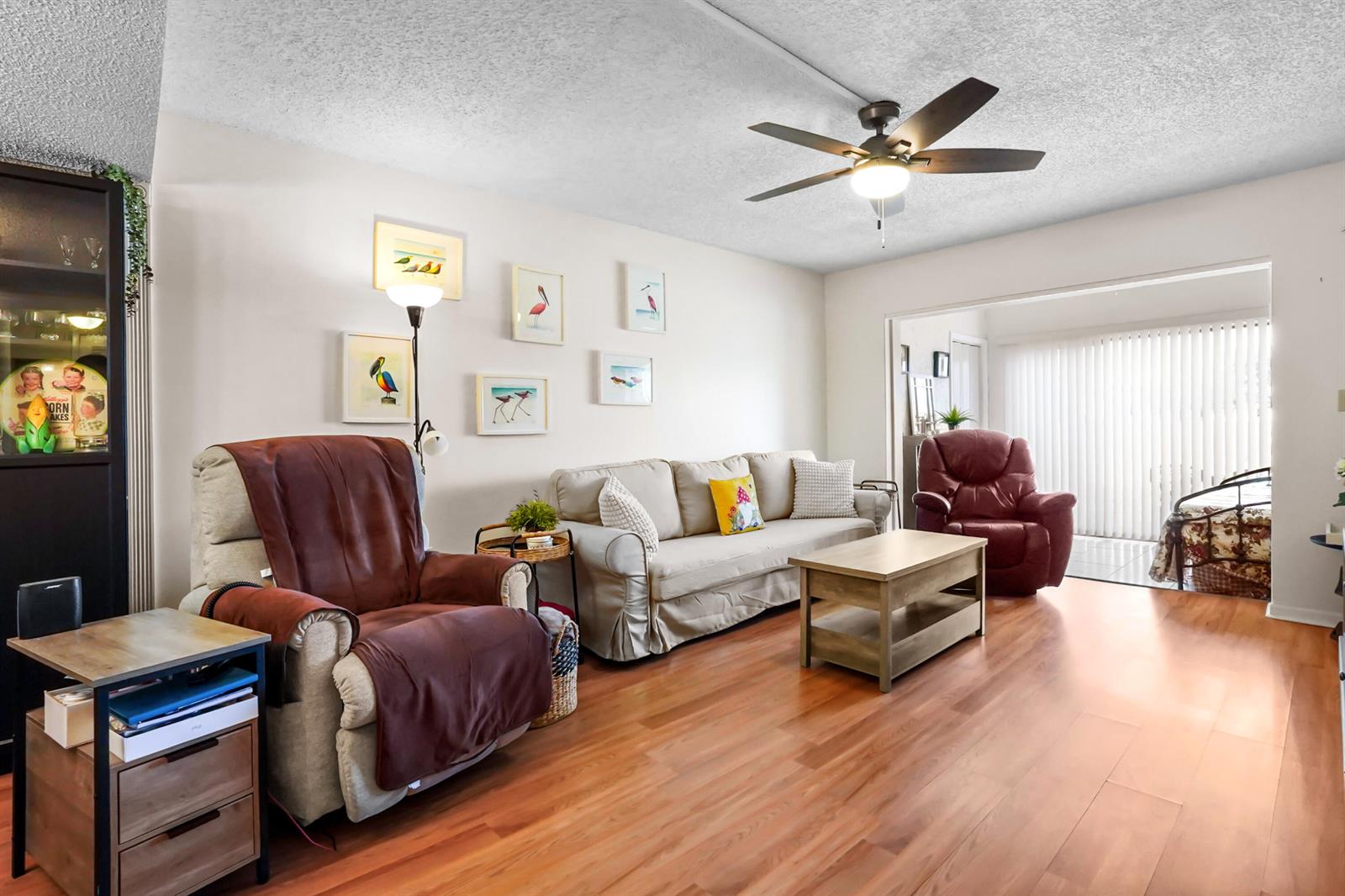 A living room features a beige sofa, two recliners, a coffee table, and wood flooring — 5355 SE Miles Grant Road # 114, Stuart FL 34997, STUART, FL