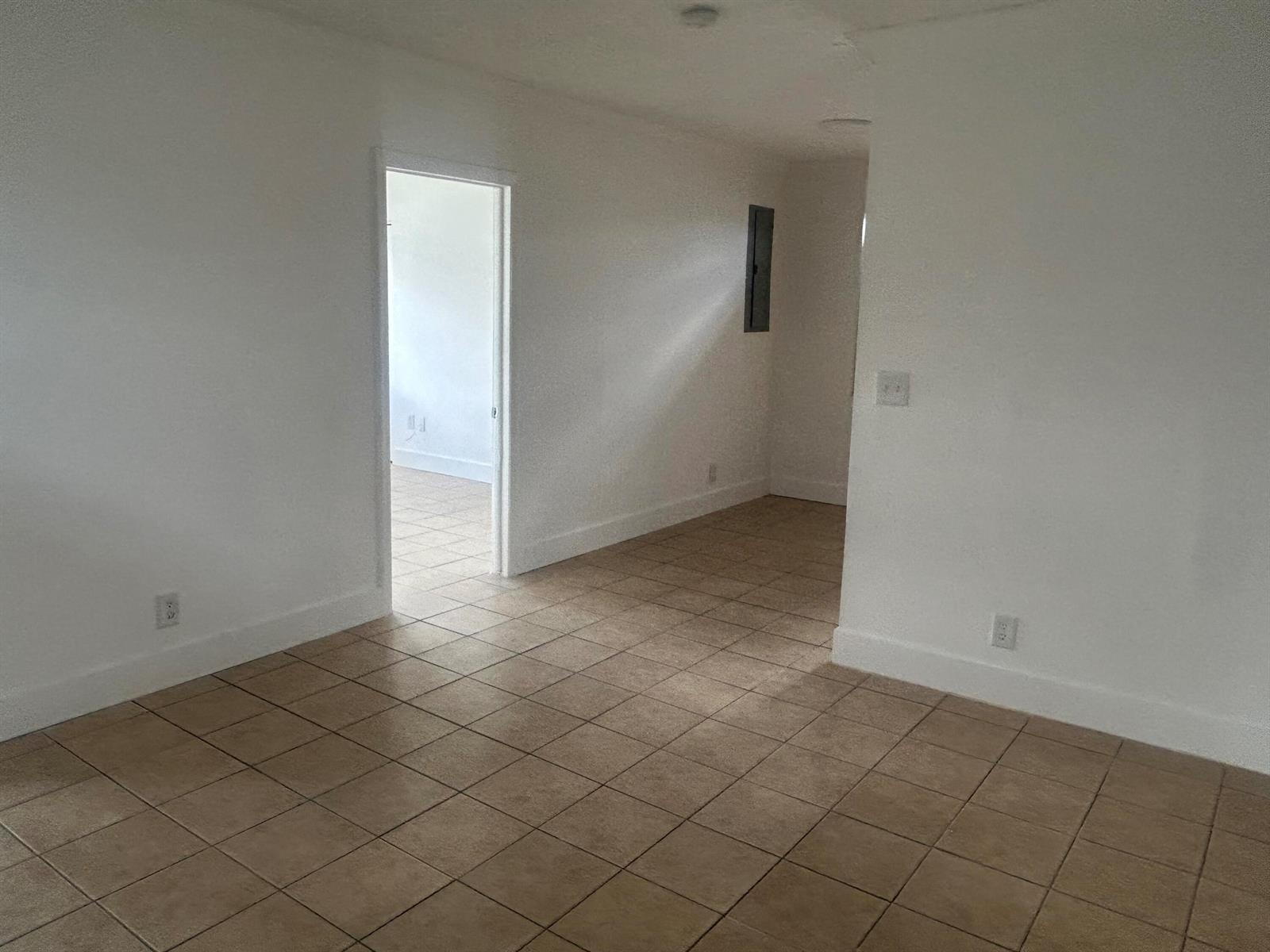 An interior view shows a room with beige tile flooring, white walls, and a doorway — 1528 S Avenue # 0, Riviera Beach FL 33404, RIVIERA BEACH, FL