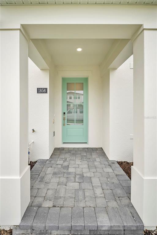 A front entryway features a light blue door, white columns, and a gray paver walkway — 1856 CROWNCREST DRIVE, APOPKA, FL