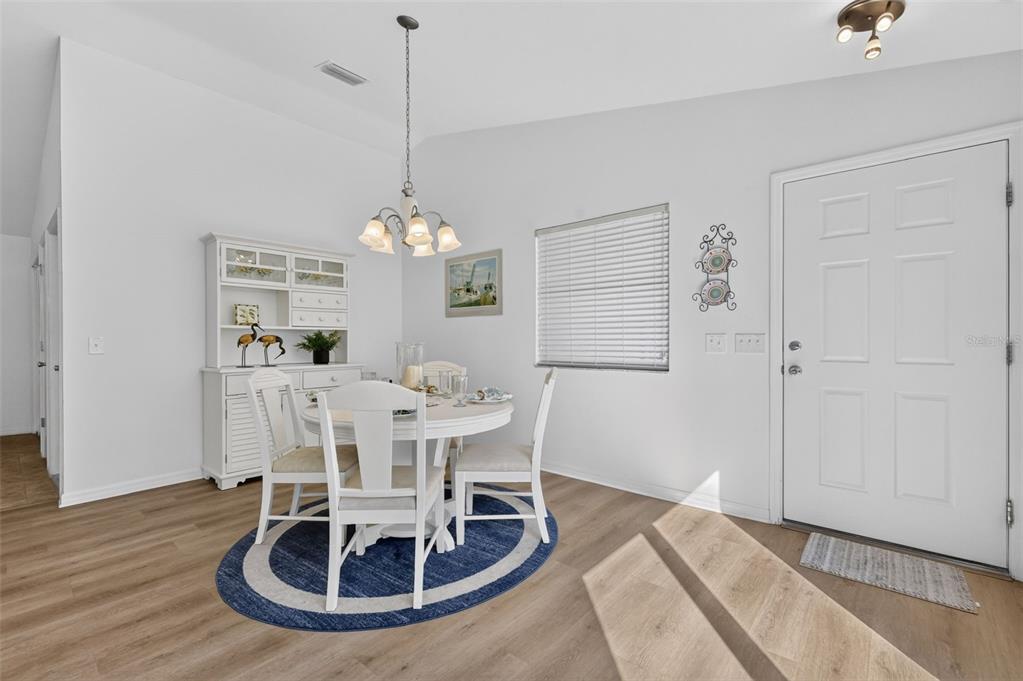 A dining area with a white table, chairs, hutch, and light wood-look flooring — 2581 ERROL TERRACE, THE VILLAGES, FL