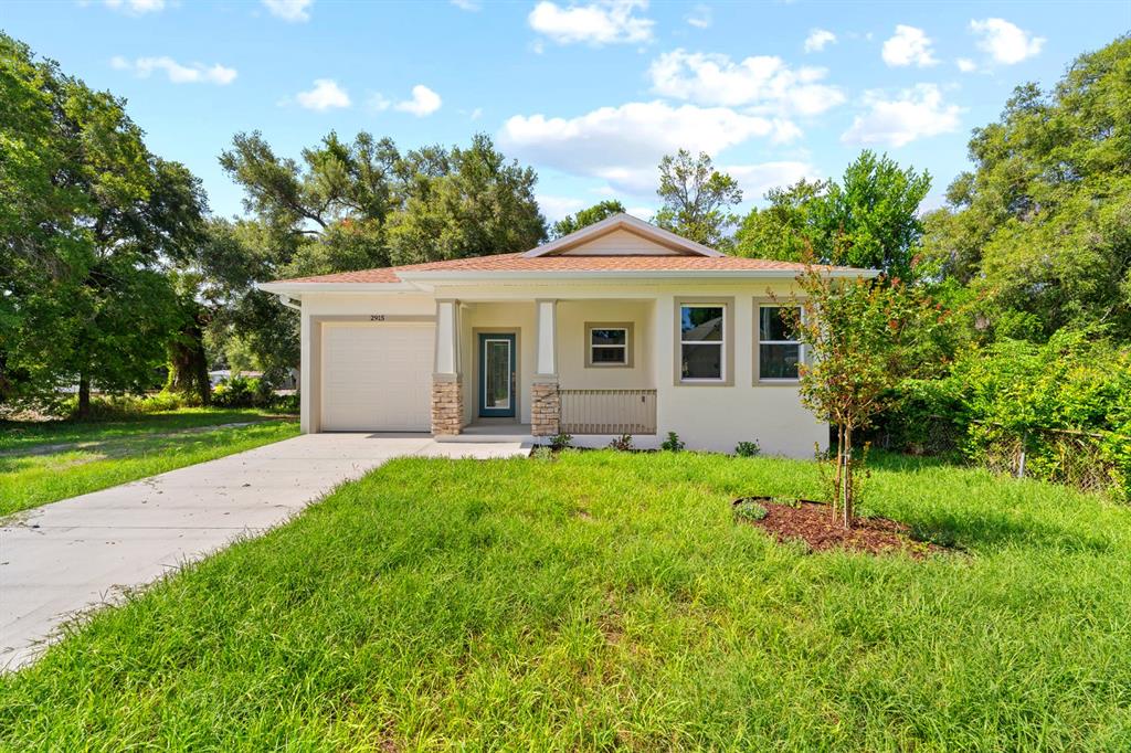A single-story house with a white exterior, a front porch, and a concrete driveway — 2915 CHIPCO STREET, TAMPA, FL