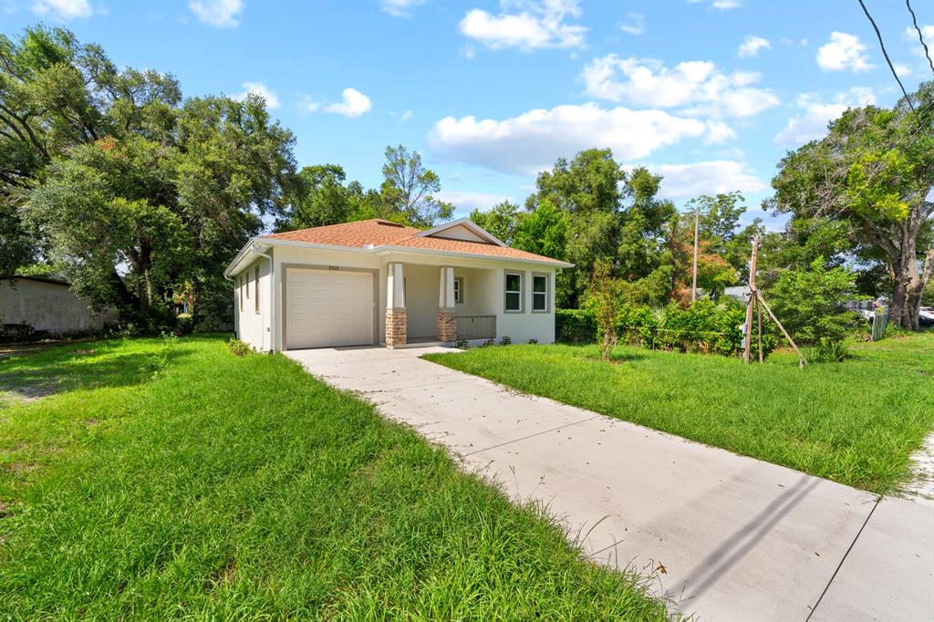A single-story house with a white exterior, a front-facing garage, and a concrete driveway — 2915 CHIPCO STREET, TAMPA, FL