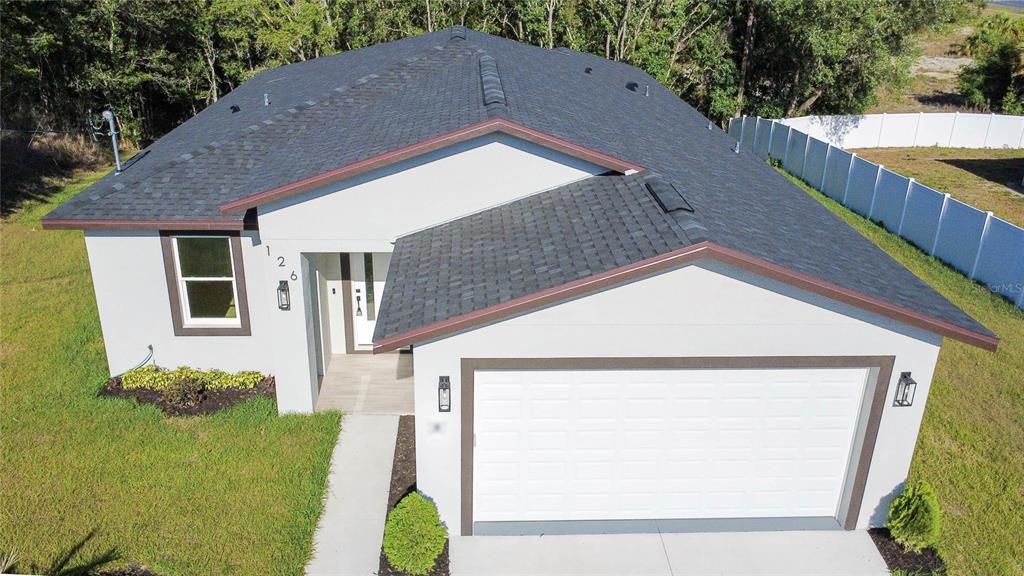 An aerial view of a single-story house with a white stucco exterior and asphalt roof — 126 CANBY CIRCLE, SPRING HILL, FL
