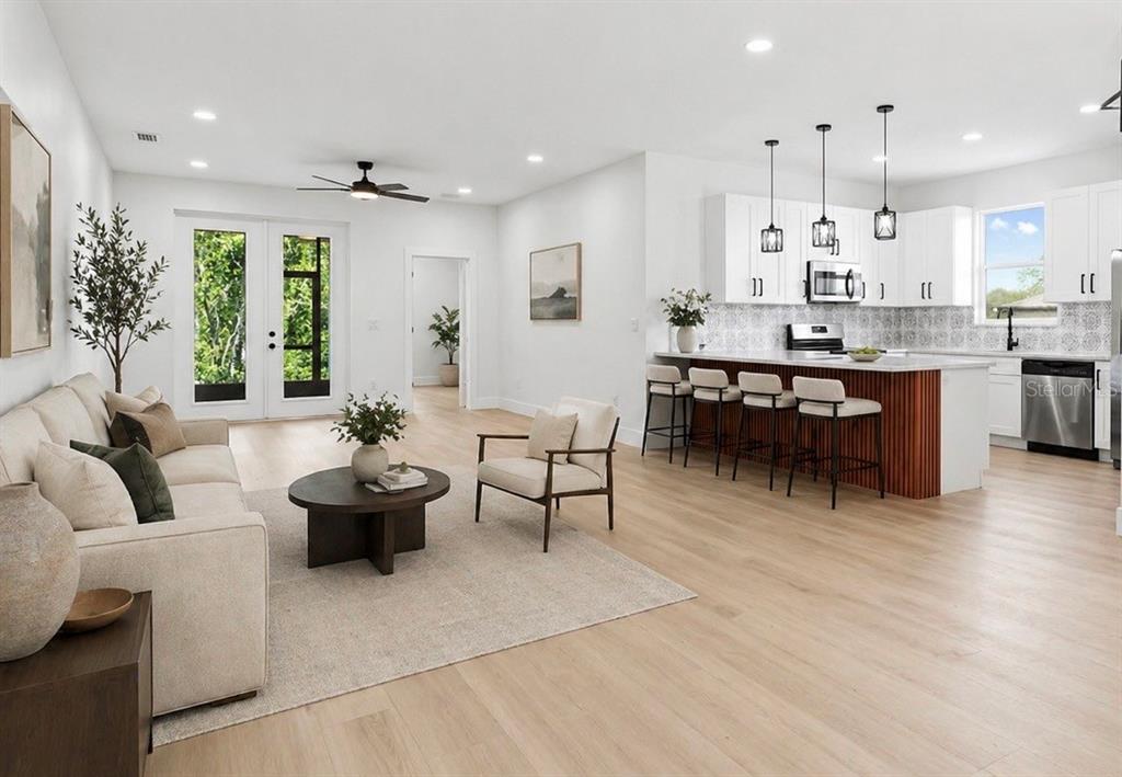 An open-concept living room and kitchen with light wood floors and a kitchen island — 126 CANBY CIRCLE, SPRING HILL, FL