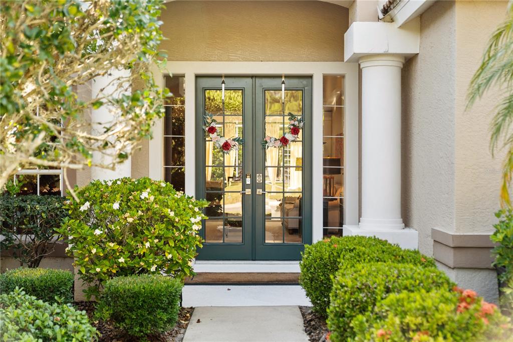 A front entrance features dark green double glass doors flanked by white columns and landscaping — 8224 WATERVIEW BOULEVARD, LAKEWOOD RANCH, FL