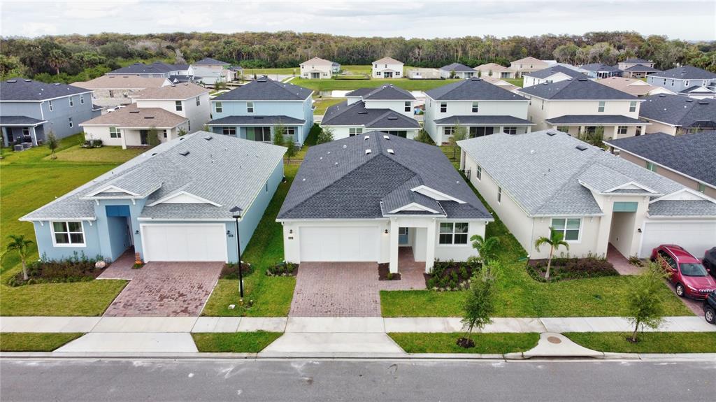 An aerial view shows three suburban houses with paved driveways and gray shingled roofs — 3540 STONEBRIAR LANE, SANFORD, FL