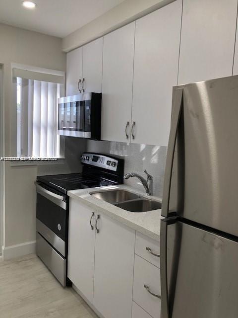 A kitchen features white cabinets, stainless steel appliances, and a double-basin sink — 3530 SW 9th Ter # 6B, Miami FL 33135, MIAMI, FL