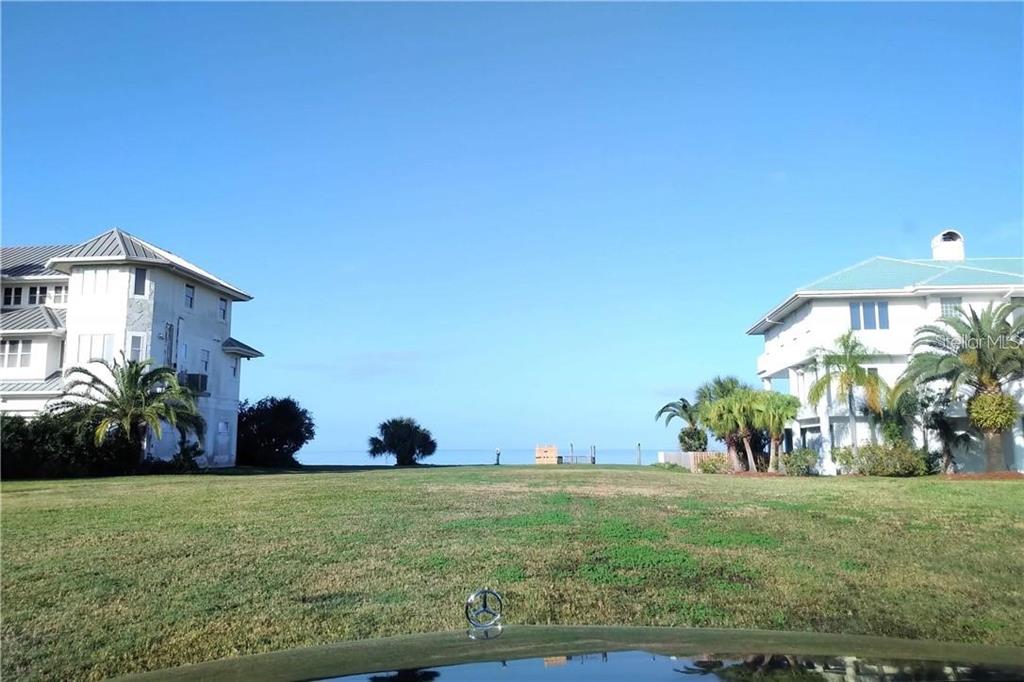 A grassy lot sits between two large houses with a view of the ocean beyond — 21 WESTSHORE DRIVE, NEW PORT RICHEY, FL