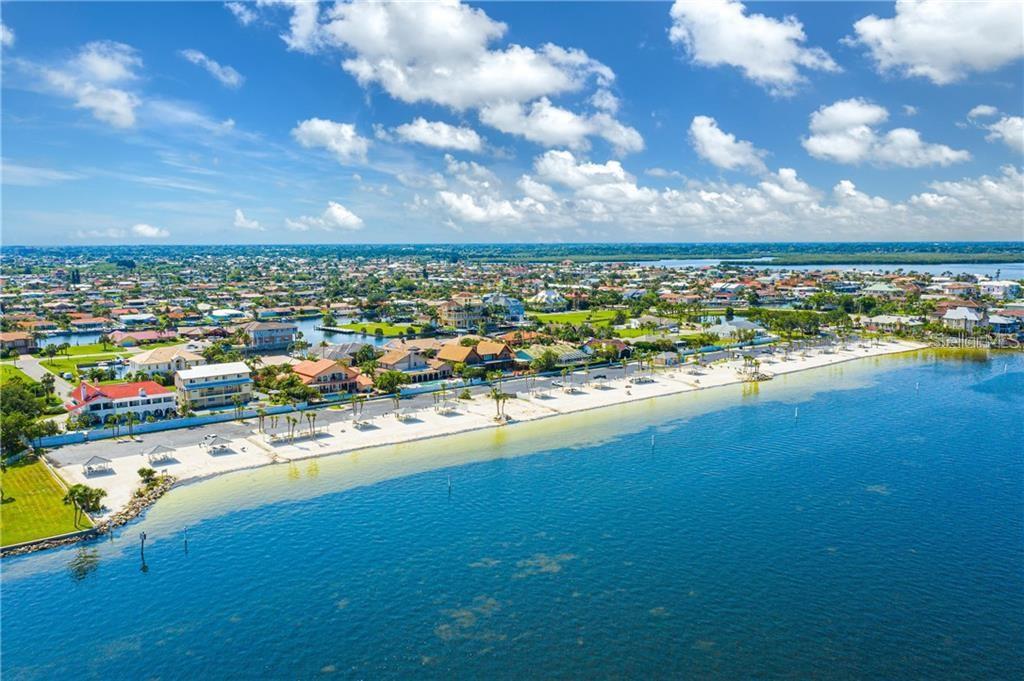 An aerial view of a sandy beach along a blue bay with coastal residential homes — 21 WESTSHORE DRIVE, NEW PORT RICHEY, FL