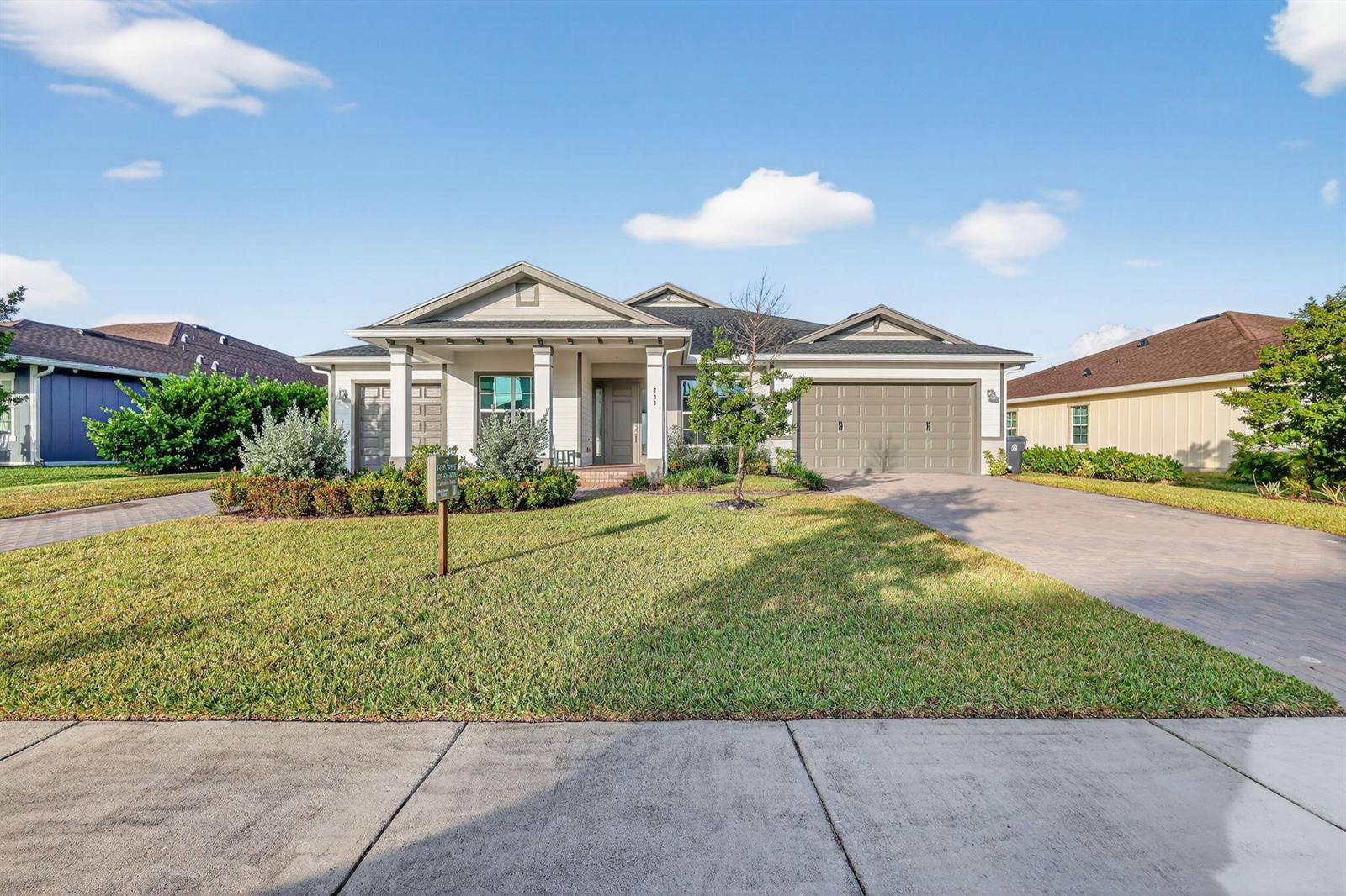 A single-story house with a beige exterior, a two-car garage, and a paved driveway — 799 Hookline Circle, Loxahatchee FL 33470, LOXAHATCHEE, FL