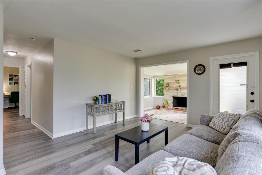 A living room with gray flooring, a gray sofa, a coffee table, and a fireplace — 3213 NORMANDY DRIVE E, PORT CHARLOTTE, FL