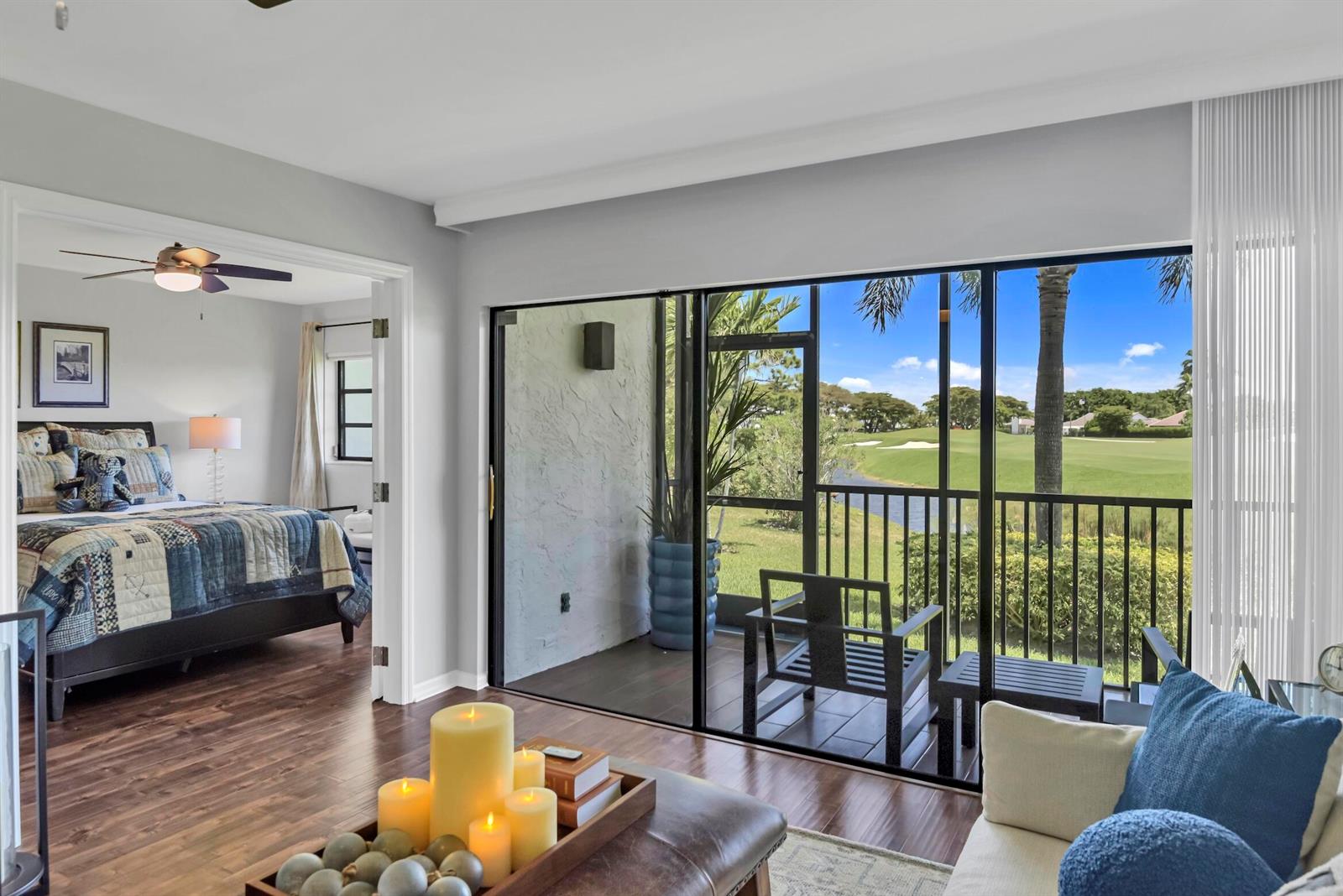 A kitchen with white cabinets and granite countertops opens into a living room with seating — 401 Greensward Lane # a, Delray Beach FL 33445, DELRAY BEACH, FL
