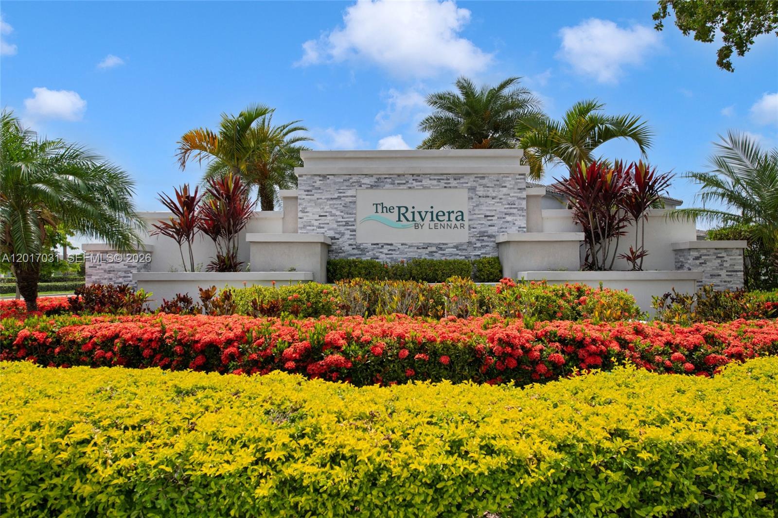 A stone monument sign for The Riviera by Lennar sits behind colorful landscaping and palms — 1392 SE 26th Ter, Homestead FL 33035, HOMESTEAD, FL