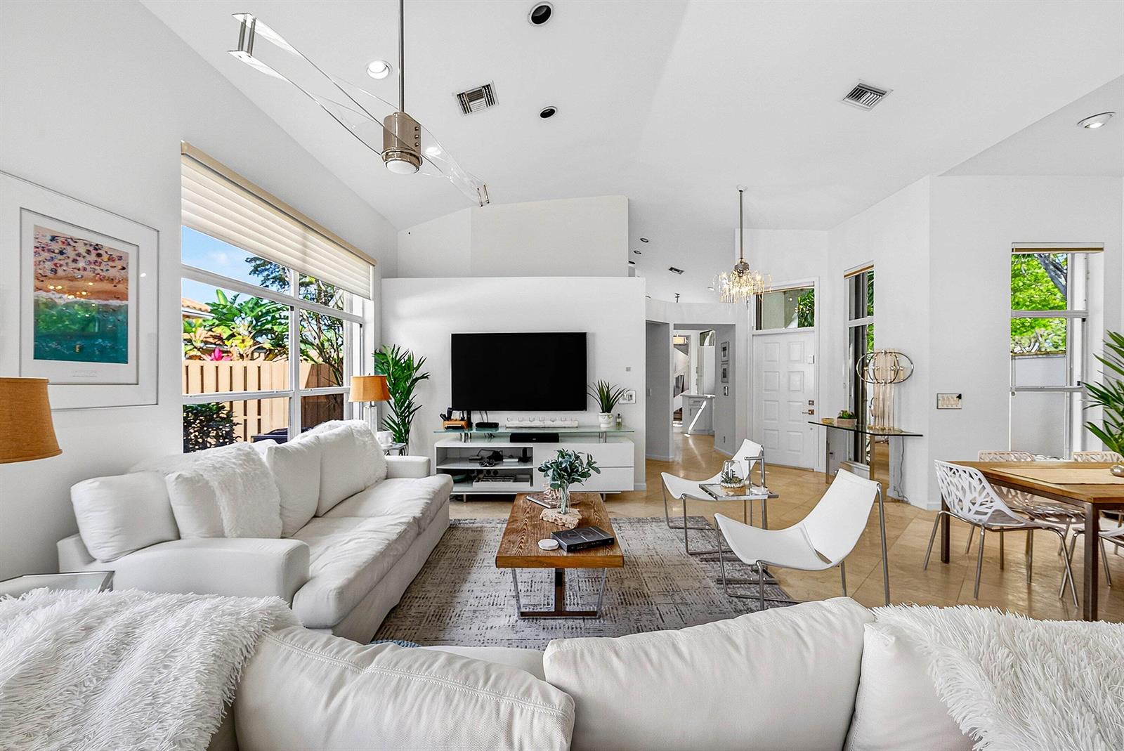 A bright, open-concept living room features white sofas, a wooden coffee table, and vaulted ceilings — 6601 NW 26th Way, Boca Raton FL 33496, BOCA RATON, FL