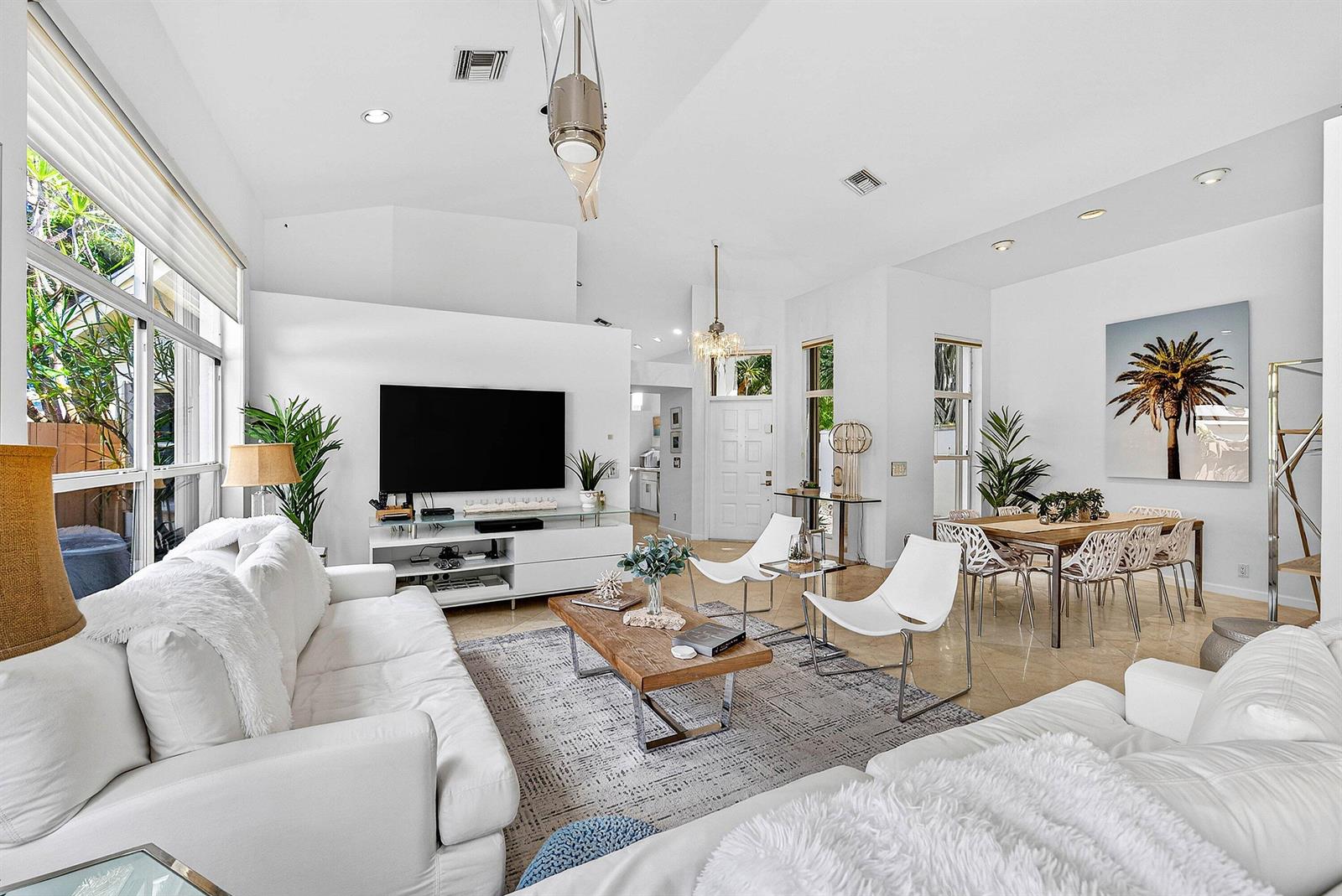 A bright living and dining area features white furniture, a wood coffee table, and tile floors — 6601 NW 26th Way, Boca Raton FL 33496, BOCA RATON, FL