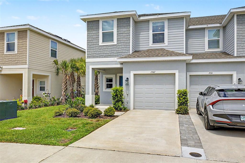 Two chairs and a small table sit on a patio overlooking a pond — 2307 PARAVANE WAY, WESLEY CHAPEL, FL