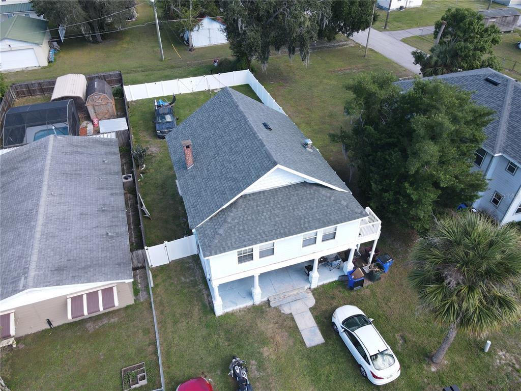 An aerial view shows a two-story white house with a gray shingled roof — 817 OHIO AVENUE, ST CLOUD, FL