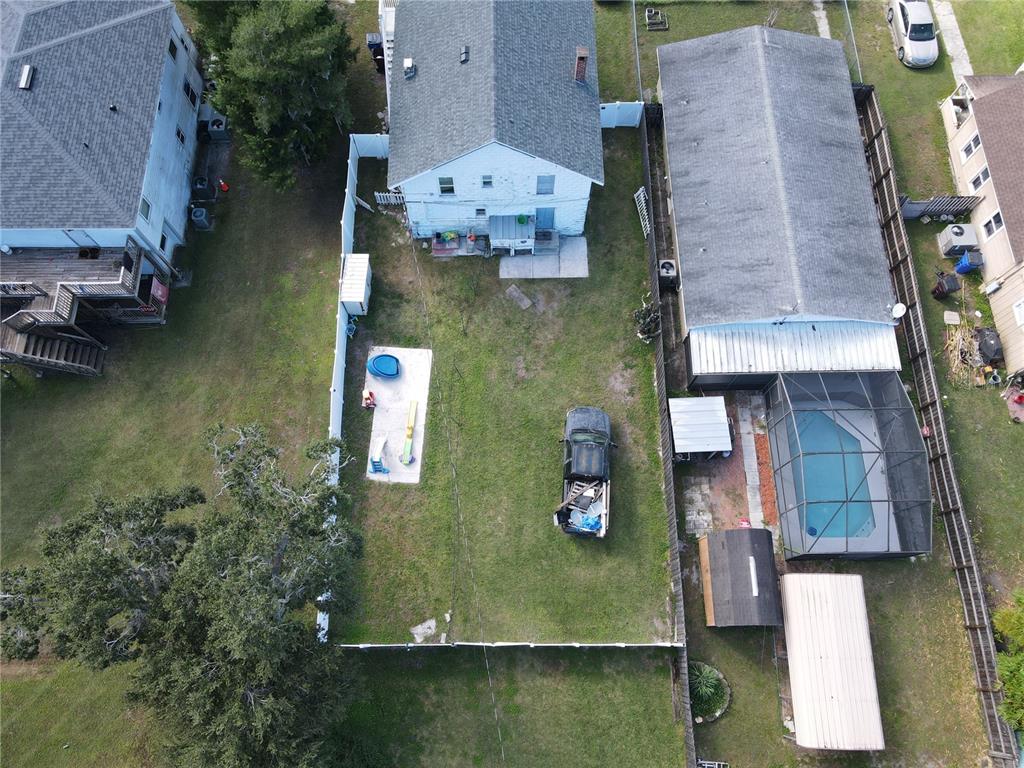 An aerial view shows a fenced backyard with a pool, a truck, and two houses — 817 OHIO AVENUE, ST CLOUD, FL