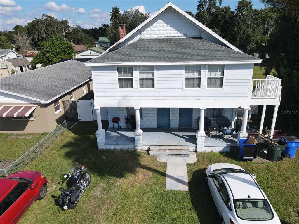 An exterior view of a two-story house with a front porch and a gravel driveway — 817 OHIO AVENUE, ST CLOUD, FL