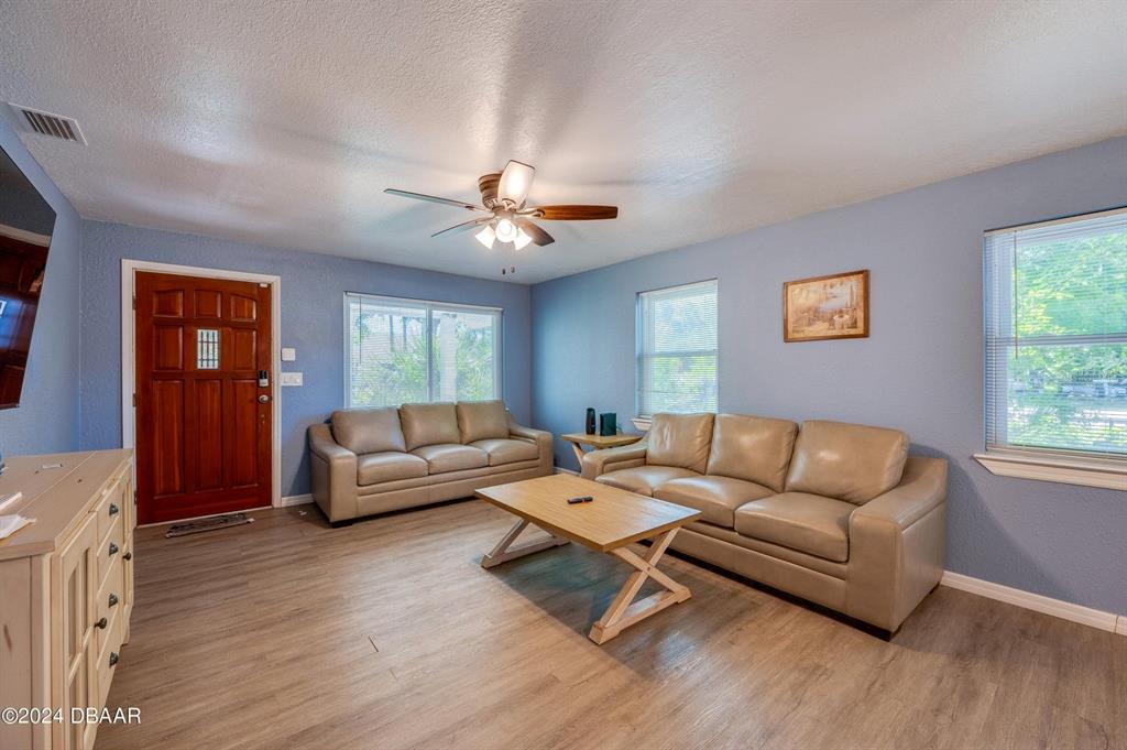 A living room features two beige sofas, a wooden coffee table, and light blue walls — 112 CENTER STREET, DAYTONA BEACH, FL