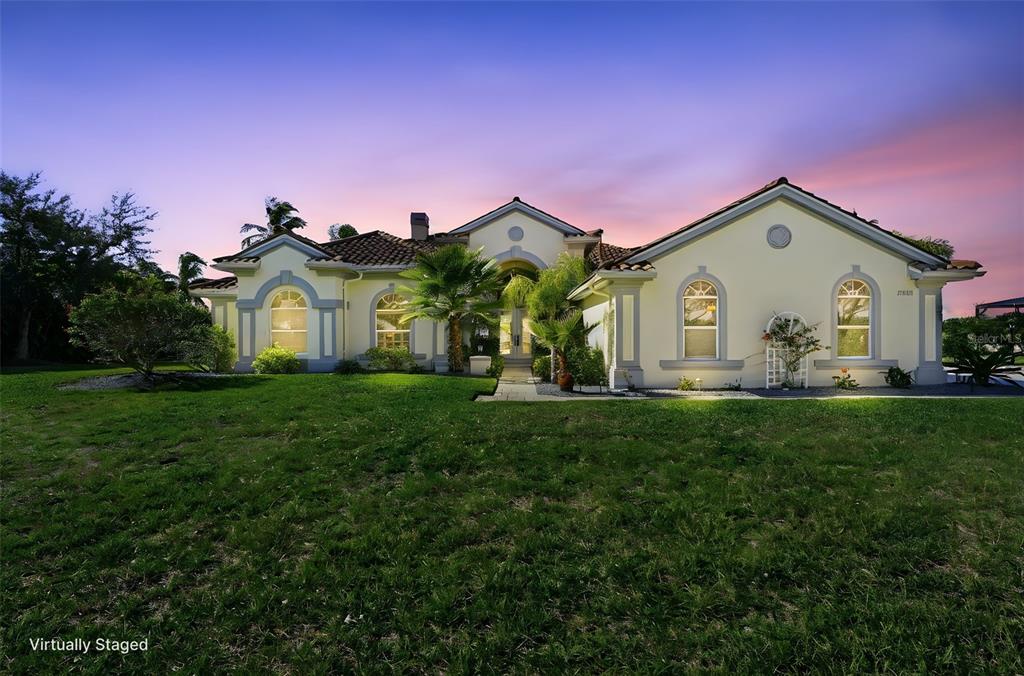 A single-story house with a tile roof and arched windows at sunset — 3121 RIVERSHORE LANE, PORT CHARLOTTE, FL