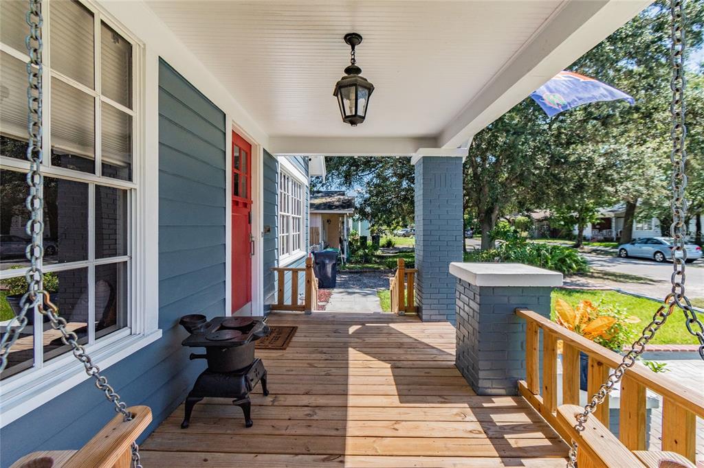 A living room features hardwood floors, a white brick fireplace, and black-framed windows — 310 E PARIS STREET, TAMPA, FL