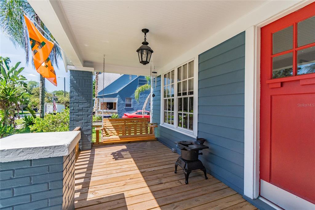 A living room features light hardwood floors, a white brick fireplace, and a ceiling fan — 310 E PARIS STREET, TAMPA, FL