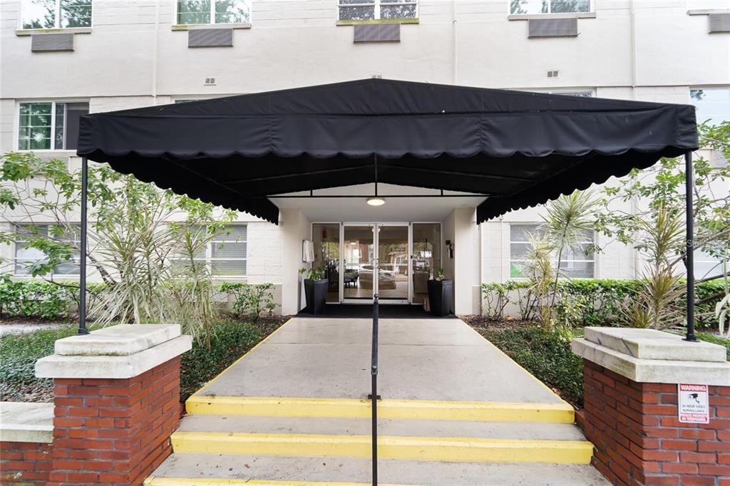 A black awning covers the concrete entrance steps leading to a glass-paned building doorway — 406 S CEDAR AVENUE UNIT 307, TAMPA, FL