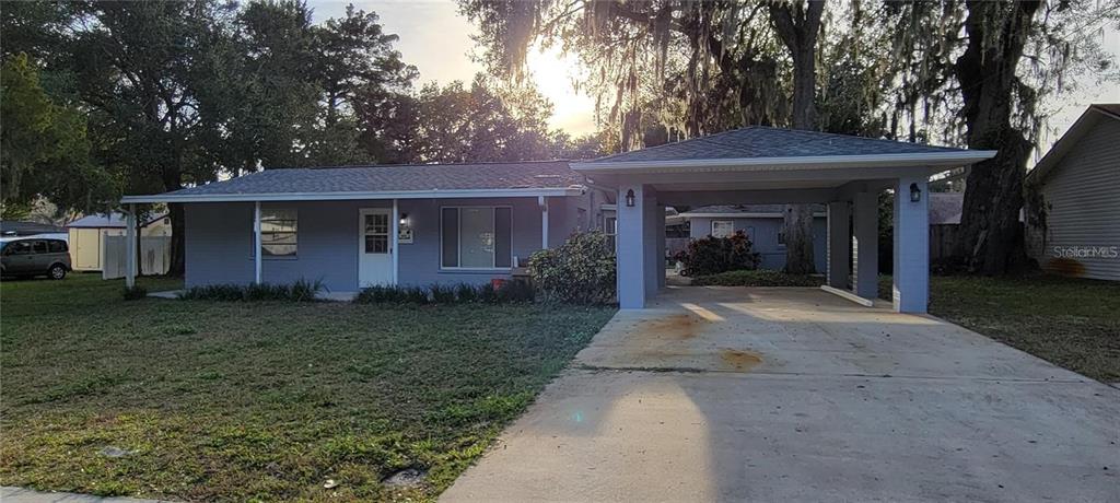 A single-story gray house with a front carport and a concrete driveway — 340 TROPICAL LN, ORMOND BEACH, FL